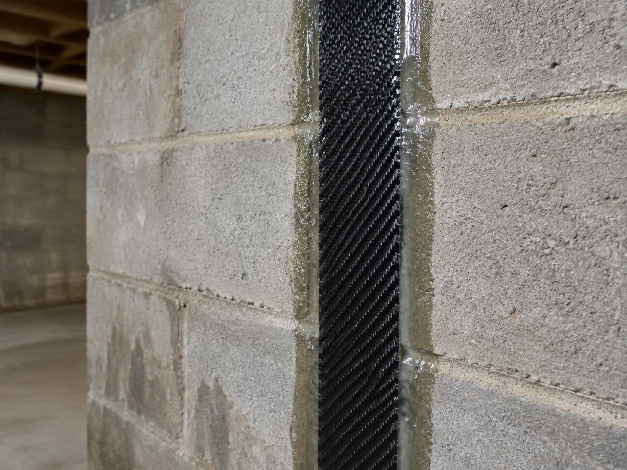 Carbon fiber strap epoxy bonded to a concrete block basement wall in Southern Iowa